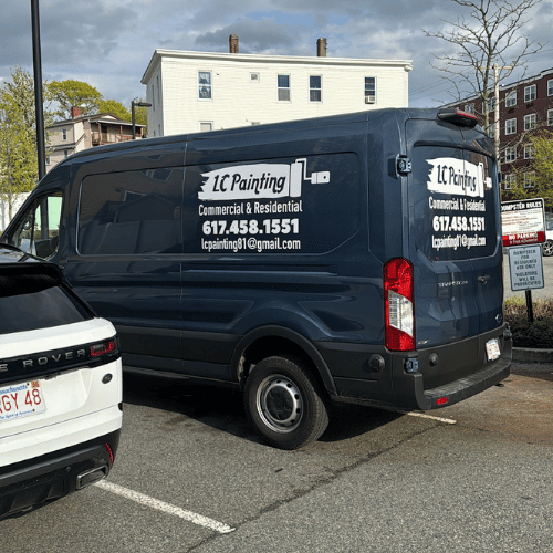 A professional painter carefully painting a wall edge.